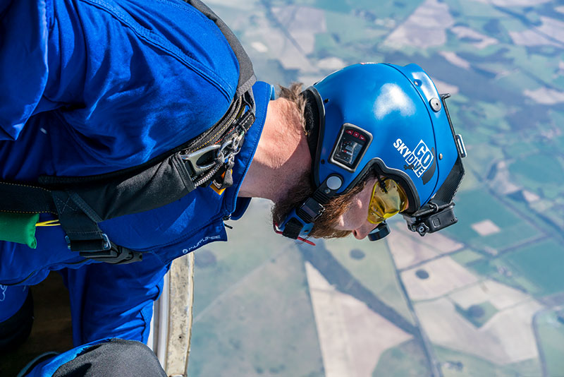 GoSkydive camera operator looking out of aircraft at ground below