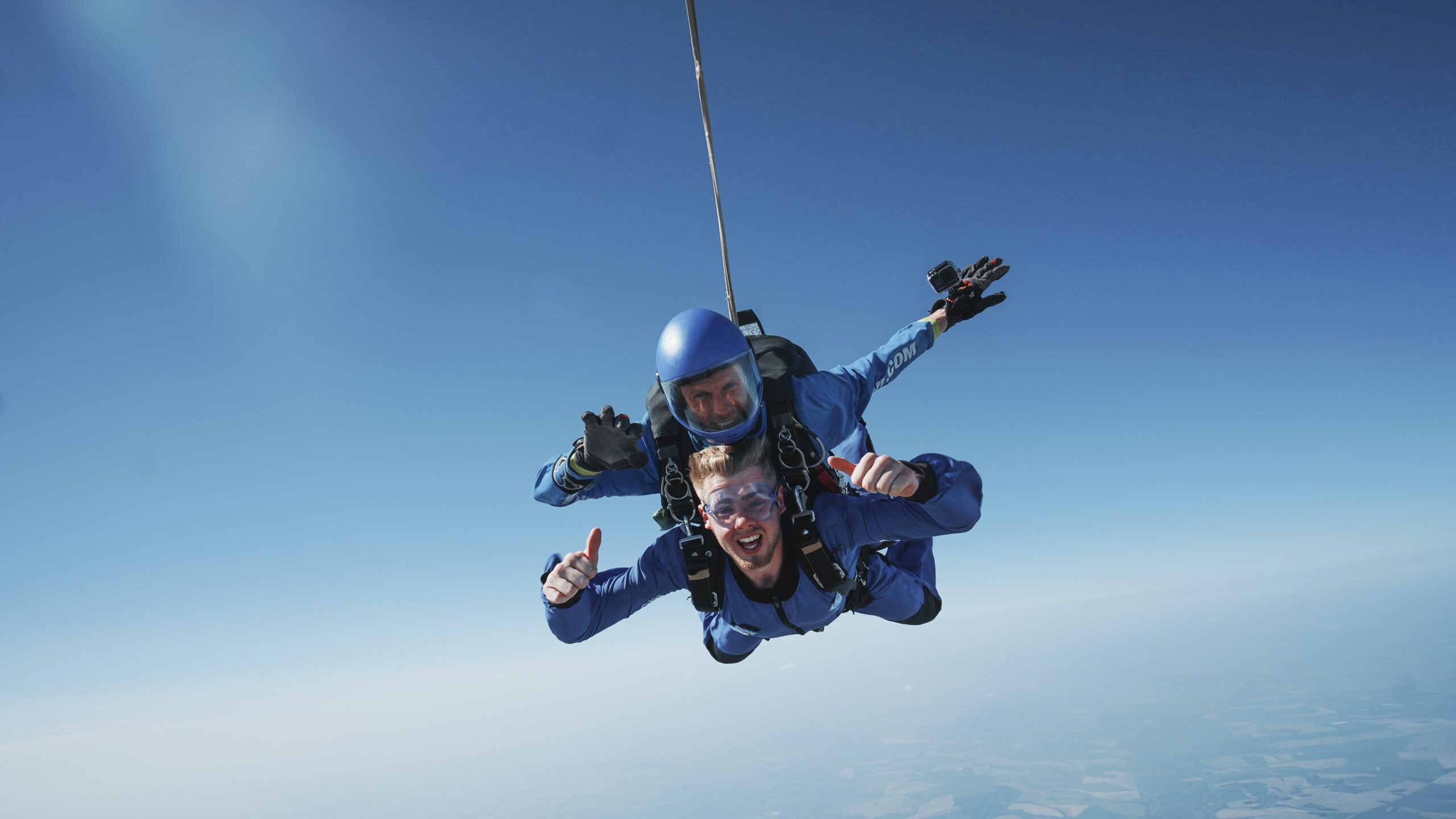 Tandem skydivers facing camera and smiling