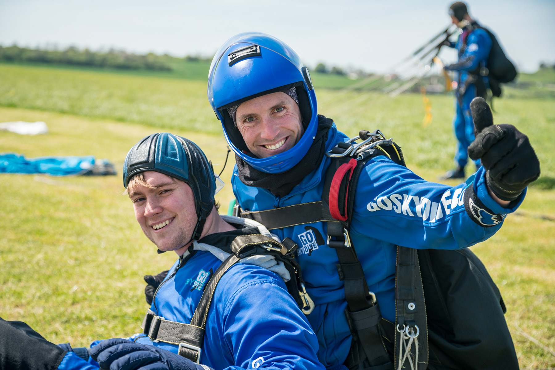 Skydive instructor Mike and customer smiling at camera after landing