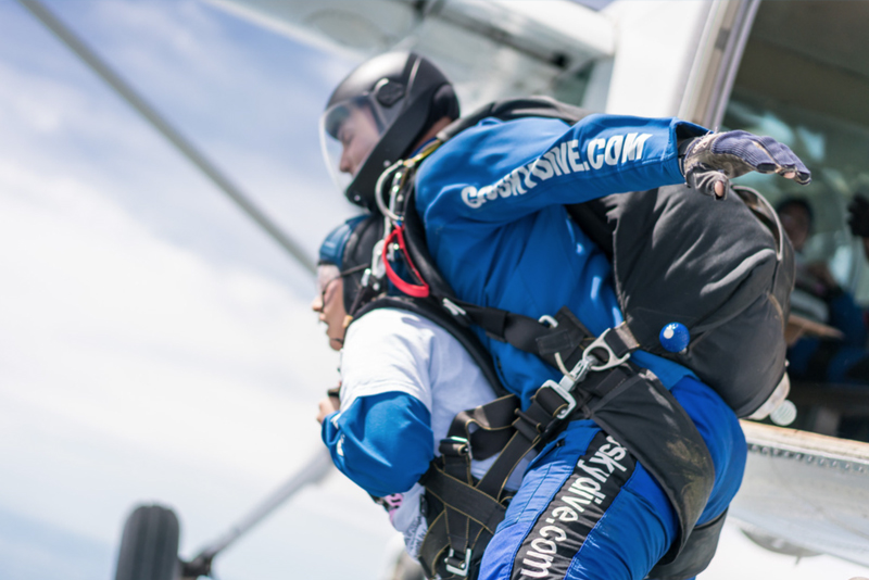 Tandem skydiver and instructor exiting the plane